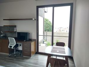 an office with a desk and chairs and a window at Suite Loft Deslumbrante Salida a México 102A in Querétaro
