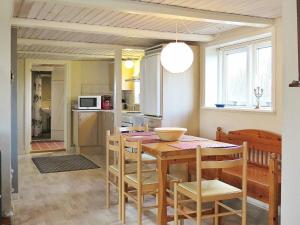 kuchnia i jadalnia ze stołem i krzesłami w obiekcie 4 person holiday home in Lemvig w mieście Trans
