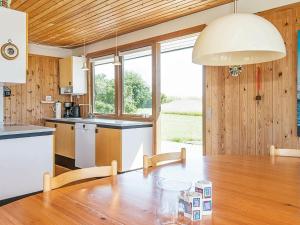 a kitchen with a wooden table and a large window at 7 person holiday home in Knebel in Knebel
