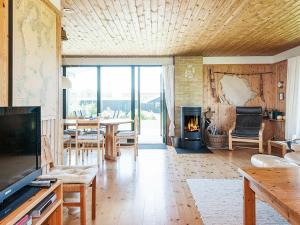 a living room with a fireplace and a table at 7 person holiday home in Knebel in Knebel
