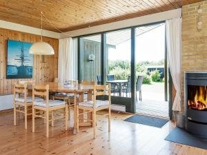 a dining room with a table and a fireplace at 7 person holiday home in Knebel in Knebel