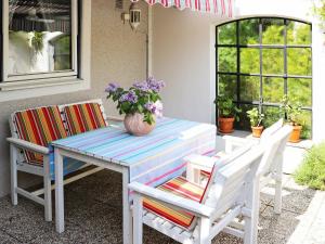 una mesa con dos sillas y un jarrón con flores. en 3 person holiday home in H LLVIKEN en Höllviken