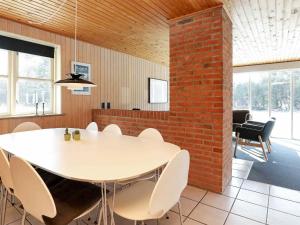 jadalnia z białym stołem i ceglaną ścianą w obiekcie 8 person holiday home in Bl vand w mieście Blåvand