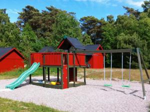 een speeltuin met een glijbaan en een schommel bij 6 person holiday home in Nex in Snogebæk