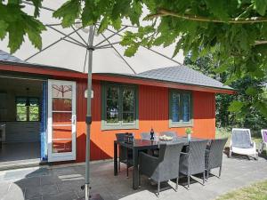 a table with an umbrella in front of a house at 6 person holiday home in Nex in Snogebæk