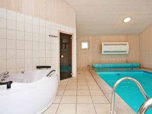 a bathroom with a tub and a swimming pool at 10 person holiday home in Gilleleje in Gilleleje