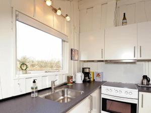 Hejlsにある8 person holiday home in Hejlsの白いキャビネット、シンク、窓付きのキッチン