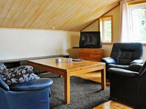 ユシーレにあるFour-Bedroom Holiday home in S-Uddvallaのリビングルーム(椅子2脚、テーブル、テレビ付)