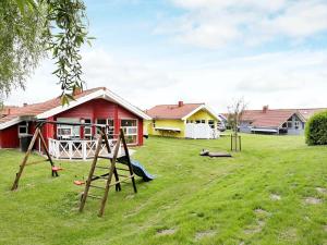 einen Hof mit Spielgeräten vor einem Haus in der Unterkunft 6 person holiday home in Otterndorf in Otterndorf