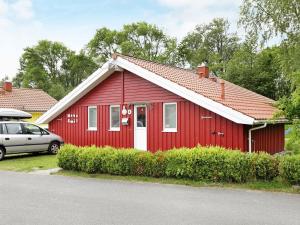 a red house with a car parked in front of it at 6 person holiday home in Otterndorf in Otterndorf
