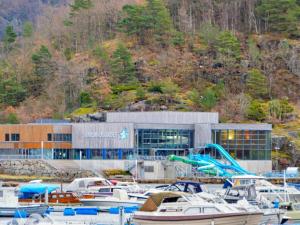 vor einem Gebäude angedockte Boote in der Unterkunft 6 person holiday home in lyngdal in Lyngdal