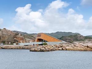 ein Gebäude am Ufer eines Wasserkörpers in der Unterkunft 6 person holiday home in lyngdal in Lyngdal