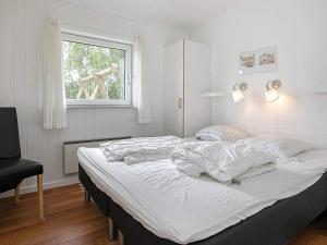 Fjand Gårdeにある6 person holiday home in Ulfborgのベッドルーム1室(白いシーツ付きのベッド1台、窓付)
