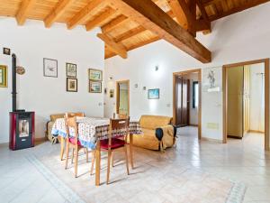 een woonkamer met een tafel en stoelen en een open haard bij Belvilla by OYO Villa Manca in Santa Giusta