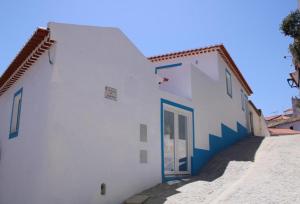 a white building with a door on the side of it at Sudoeste Guest House in Odeceixe