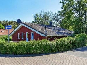 una casa rossa con un tetto nero su una strada di Three-Bedroom Holiday home in Grömitz 7 a Grömitz