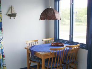mesa de comedor con 3 sillas y mantel azul en One-Bedroom Holiday home in Stenungsund en Stenungsund