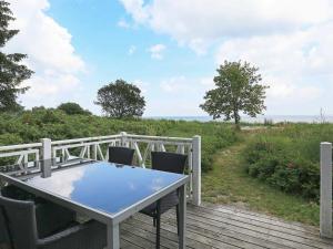 een tafel en stoelen op een terras met uitzicht op de oceaan bij 4 person holiday home in Oure in Oure