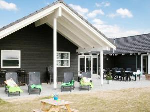 a patio with chairs and tables in front of a house at 20 person holiday home in L kken in Nørre Lyngby