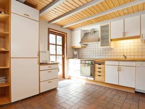 een keuken met witte kasten en een houten plafond bij Holiday Home Tane Hedevej in Blåvand