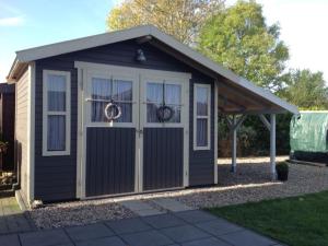 a black and white shed with a door at Ferienhaus in Zierow am Strand in Zierow