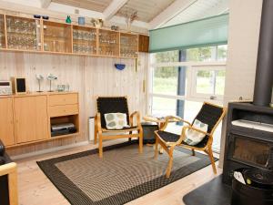 a living room with two chairs and a stove at 10 person holiday home in lb k in Skram