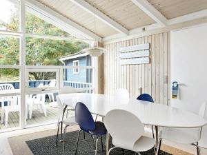 a white dining room with a white table and chairs at 10 person holiday home in lb k in Skram