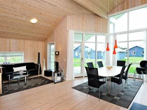 een woonkamer met een tafel en stoelen en een bank bij 8 person holiday home in Ulfborg in Fjand Gårde