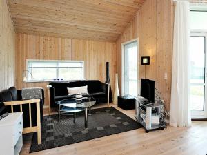 een woonkamer met een bank en een tafel bij 8 person holiday home in Ulfborg in Fjand Gårde
