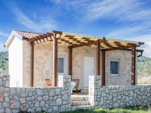 a stone house with a pergola on a stone wall at Secluded Holiday Home in Pa man with Sea nearby in Pašman