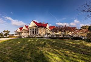 une grande maison avec une grande pelouse devant elle dans l'établissement Pen-y-bryn Lodge, à Oamaru
