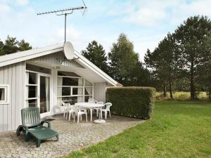 a building with a patio with a table and chairs at 8 person holiday home in R dby in Kramnitse