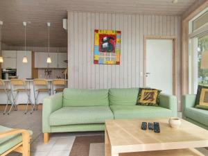 Knebelにある6 person holiday home in Knebelのリビングルーム(緑のソファ、テーブル付)