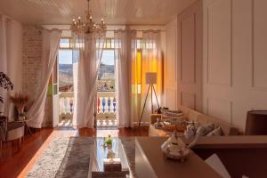 a living room with a chandelier and a large window at HOTEL CANTO DO CHAFARIZ in Diamantina