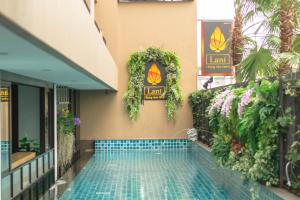 a swimming pool next to a building with plants at Lani Chiang Mai Hotel in Chiang Mai