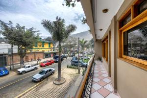 a balcony with a palm tree and a street at Hostal Primavera in Chosica