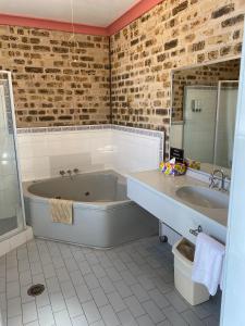 a bathroom with a tub, sink and toilet at Sir Francis Drake in Heatherbrae