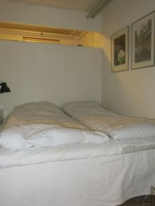 コペンハーゲンにあるApartmentInCopenhagen Apartment 1316の白いシーツが備わるドミトリールームのベッド1台分です。