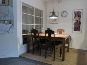 uma mesa de jantar com cadeiras e um relógio na parede em ApartmentInCopenhagen Apartment 1316 em Copenhague