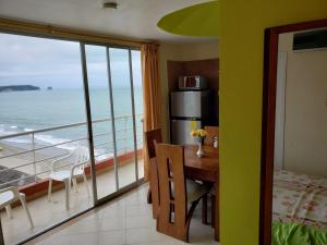 a room with a table and a view of the ocean at Arco Iris Atacames in Atacames