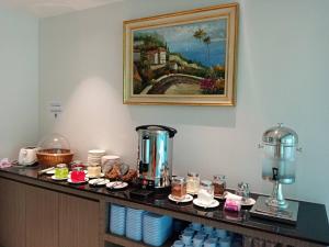 eine Theke mit Essen und ein Bild an der Wand in der Unterkunft Orchid Residence Suratthani in Surat Thani