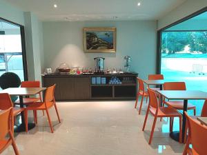 a restaurant with tables and chairs and a counter at Orchid Residence Suratthani in Suratthani