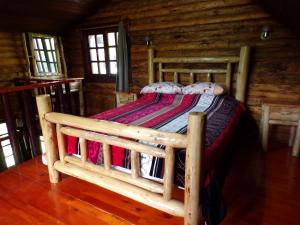 a bed in a wooden room in a cabin at Cabañas El Rincón de Pancho in Altotonga