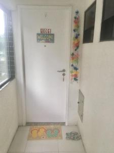 uma porta branca com um sinal que lê bem-vindo ao hotel em Lindo Ap 101 Quadra do Mar c Garagem em Recife