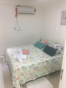 a bedroom with a bed with a floral comforter at Lindo Ap 101 Quadra do Mar c Garagem in Recife
