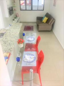 a living room with a table with plates on it at Lindo Ap 101 Quadra do Mar c Garagem in Recife