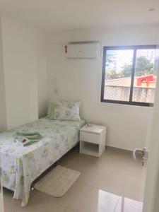 um pequeno quarto com uma cama e uma janela em Lindo Ap 101 Quadra do Mar c Garagem no Recife