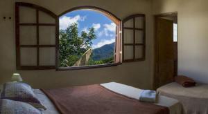 a room with two beds and a large window at Hostel Café in Alto Caparao