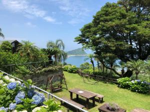 a park with a bench and a view of the water at The Little Garden in Miyazaki