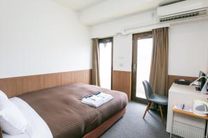 東京にあるオークホテル江戸のベッド、デスク、窓が備わるホテルルームです。